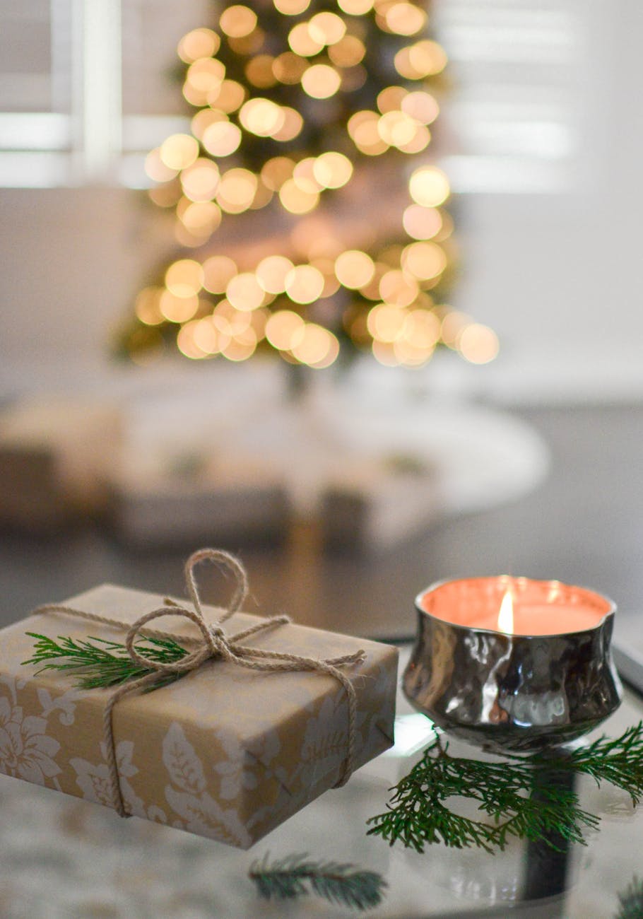 close up photography of gift besides candle