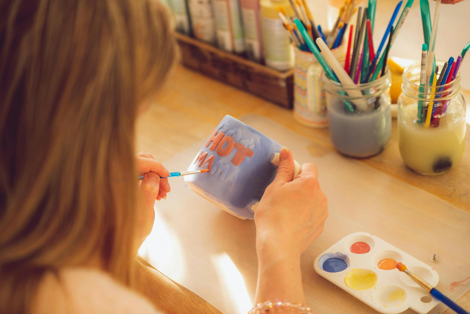 person painting on mug